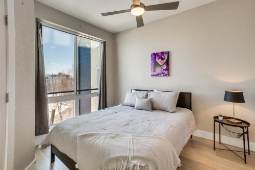 um quarto com uma cama e uma grande janela em Modern Townhome with Rooftop Hot Tub and Mtn View em Denver