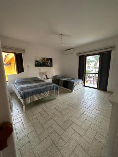 1 Schlafzimmer mit 2 Betten und Fliesenboden in der Unterkunft Cómodo Depa en Club Santiago in Manzanillo