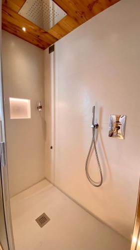a shower with a hose attached to a wall at Gran Baita Hotel & Wellness in Courmayeur