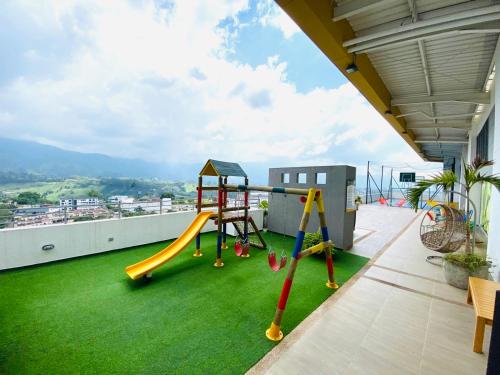 a playground on the roof of a house with green grass at Luxury apartment in Armenia