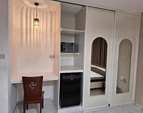a room with a kitchen with a desk and a microwave at R Garden Studio 1 - Ensuite avec accès privé et indépendant in Baie du Tombeau
