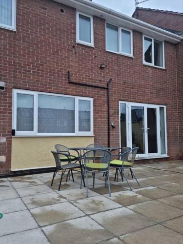 a table and chairs in front of a brick building at 5 bedroom house - Cheshire Oaks in Ellesmere Port