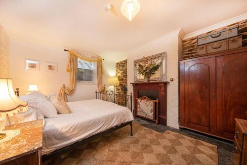 ein Schlafzimmer mit einem Bett und einem Waschbecken in einem Zimmer in der Unterkunft Burrow at Botanic in Adelaide