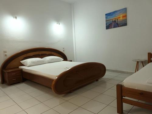 a bedroom with a large bed with a wooden headboard at Sun Ray Sivota 3 in Syvota