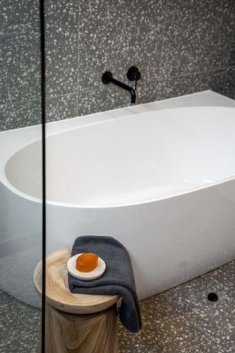 a bathroom with a bath tub with a towel on a table at Seaside on Swan Laneway Retreat in Grange