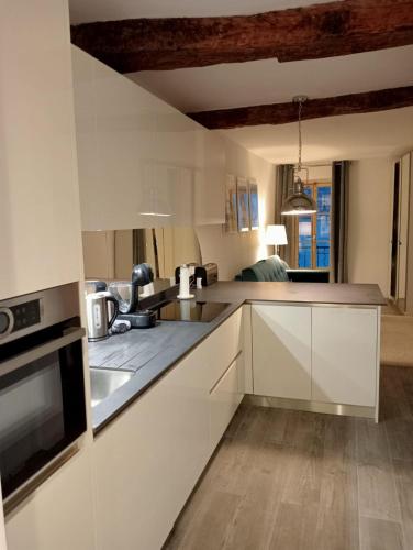 une cuisine avec des armoires blanches et un évier dans l'établissement Menton - SABLETTES BEACH VIEW, à Menton