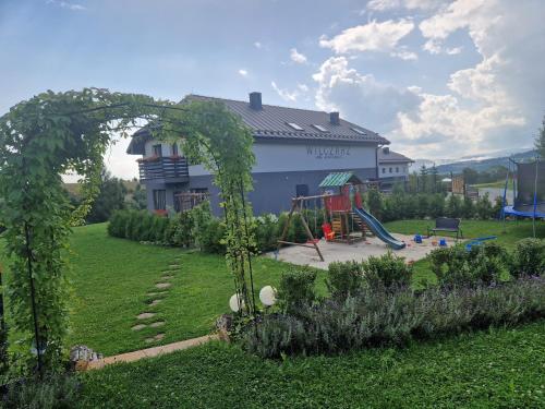 a yard with a playground in front of a house at Wilczarz in Duszniki Zdrój
