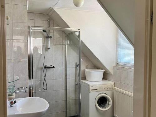 a bathroom with a shower and a washing machine at Quietly located holiday home against the Lemelerberg in Lemele