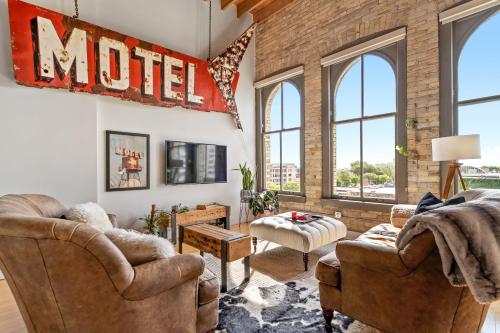a living room with two chairs and a sign that reads motel at The Goatel - 1 bdrm apartment in Milwaukee