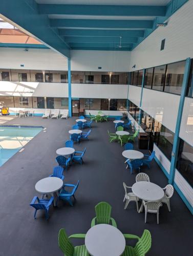 a building with tables and chairs and a pool at Woodfield Inn and Suites in Marshfield