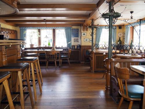 un restaurante con suelo de madera, mesas y sillas en Schieferhof, en Schmallenberg