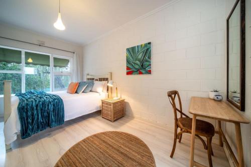 a bedroom with a bed and a table and a desk at Dreamscape on Duthy - WiFi Art in Unley