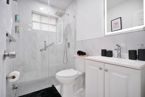ein weißes Bad mit einer Dusche und einem WC in der Unterkunft Vacay Spot Wynwood Comfort 2 Kitchen 2 BBQs Patio vibes, Prime LOC! 6 blocks away from Bars, Nite Clubs, Res, Shops in Miami