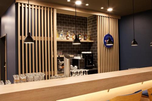 a restaurant with a bar with glasses on the wall at Holiday Inn Express - Ringsheim by IHG in Ringsheim