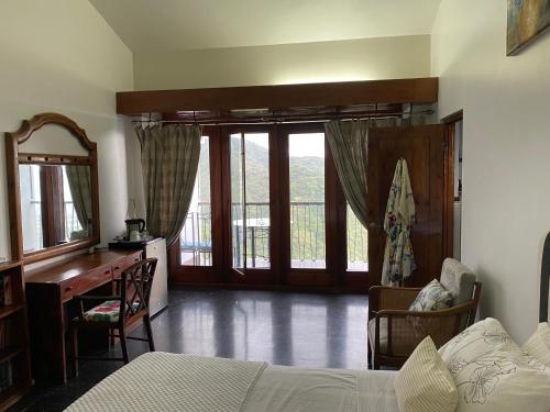 a bedroom with a bed and a desk and windows at Tranquility Estate in Kingston
