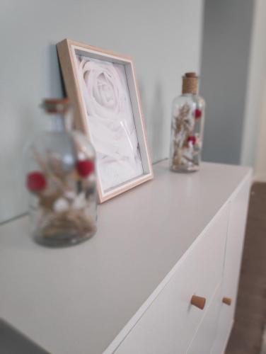 a white dresser with a picture and two vases on it at T2 neuf Le SCANDINAVE in Riom