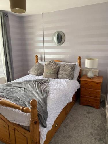 a bedroom with a bed and a night stand with a lamp at 5 min walk to Beaches & Pembrokeshire Coast Path in Pembrokeshire