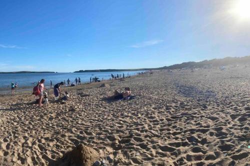 a group of people on a sandy beach at 5 min walk to Beaches & Pembrokeshire Coast Path in Pembrokeshire
