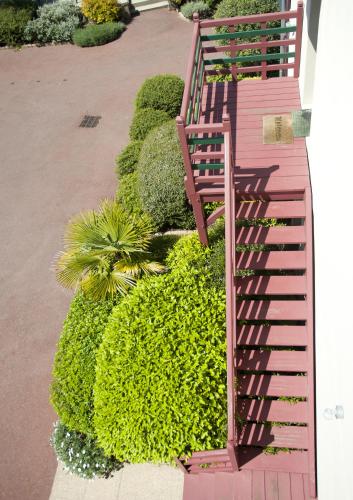 a pink staircase in a garden with green bushes at Manoir Du Cunningham in Saint Malo