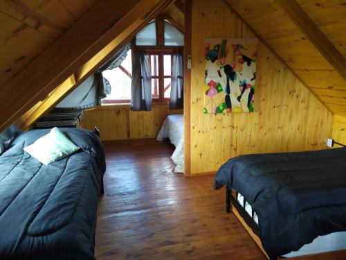 een kamer met 2 bedden op een zolder bij Cabañas en los reartes in Los Reartes