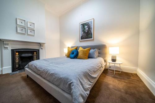 a bedroom with a large bed and a fireplace at Irmas Place on Halifax in Adelaide