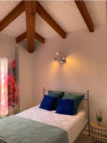une chambre avec un lit avec des oreillers bleus dessus dans l'établissement Villa de charme à Marina di fiori, à Porto-Vecchio