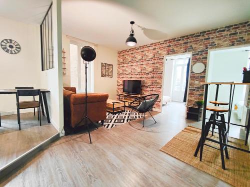 a living room with a brick wall at T3 neuf L'INDUSTRIEL in Riom