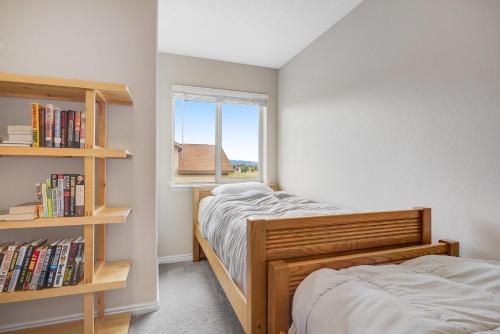 two beds in a small room with a window at Near Tamarack AC Kitchen TV Washer Dryer in Donnelly