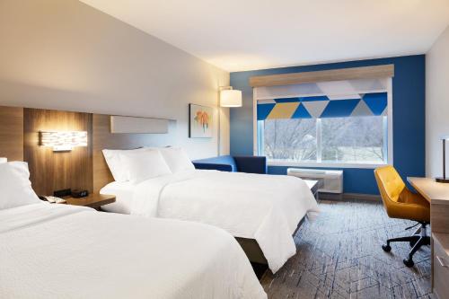 ウィネマッカにあるHoliday Inn Express Winnemucca, an IHG Hotelのベッド2台、デスク、窓が備わるホテルルームです。