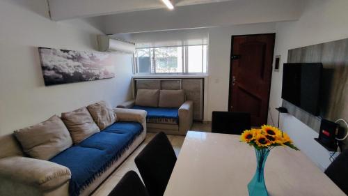 a living room with a couch and a table at Ao Lado do Aeroporto com Ar Condicionado e vaga coberta in Guarulhos