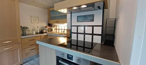 a large kitchen with a counter top in a room at Cozy studio near sea, forest and town in Brastad