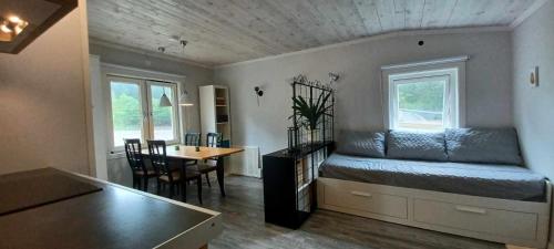 a bedroom with a bed and a dining room with a table at Cozy studio near sea, forest and town in Brastad