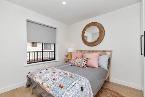 a bedroom with a bed and a mirror at Mint at Sea Mist West Beach in Henley Beach South