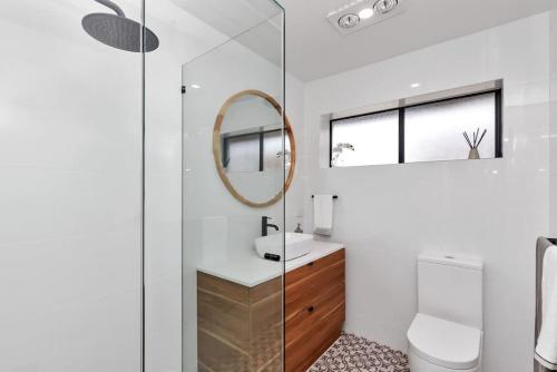 a bathroom with a toilet and a mirror at Mint at Sea Mist West Beach in Henley Beach South