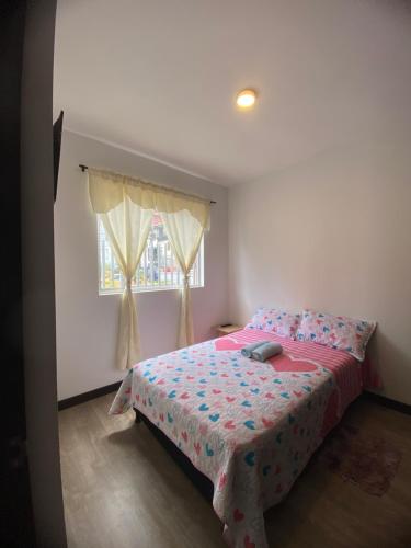 a bedroom with a bed and a window at apartamento ubicado parte histórica de manizales in Manizales
