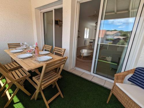 d'une table et de chaises en bois sur un balcon avec vue. dans l'établissement Bisc'Appart standing et calme à 250 m de la plage, à Biscarrosse