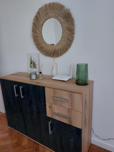 a wooden dresser with a mirror on top of it at ELI's Apartments in Iaşi