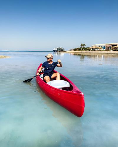 a man in a red canoe on the water at Gravity Hotel & Aqua Park Hurghada Families and Couples Only in Hurghada