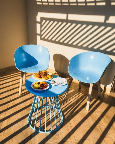 two blue chairs and a table with a plate of food on it at Gravity Hotel & Aqua Park Hurghada Families and Couples Only in Hurghada