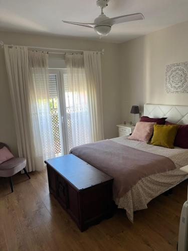 1 dormitorio con 1 cama grande y ventilador de techo en Casa con piscina cerca de Sevilla, en Sevilla