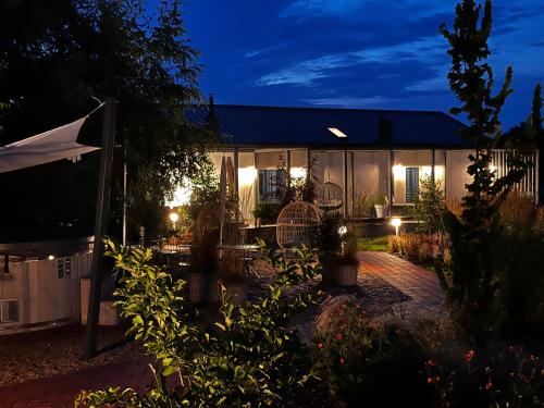 dom z oświetlonym dziedzińcem w nocy w obiekcie Botanica w mieście Odargowo