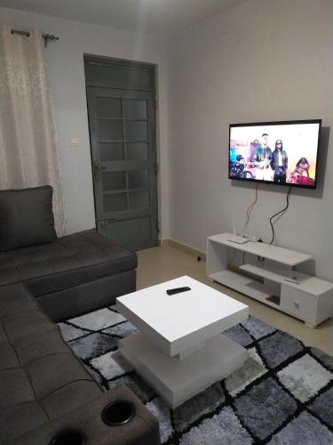 a living room with a couch and a flat screen tv at One bedroom apartments tulivu in Thika