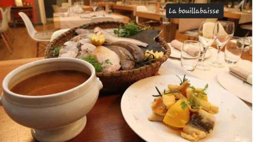 - une table avec un bol de soupe et une assiette de nourriture dans l'établissement Studio à 2 pas de la plage, à Marseille
