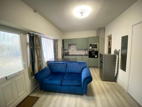 un sofá azul en una sala de estar con cocina en Ground floor apartment Brean en Brean