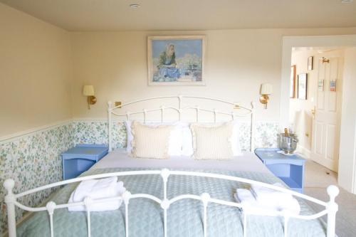 a bedroom with a white bed and two blue cabinets at Fleur de Lys Bampton in Bampton