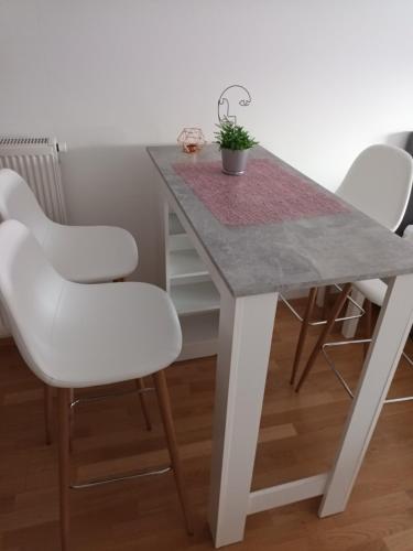 a white dining room table with white chairs and a gray table at Gajeva Rooms - Malmö apartment SELF CHECK-IN in Virovitica