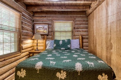 a bedroom with a bed in a log cabin at VERY private, real log cabin with hot tub! in Sevierville