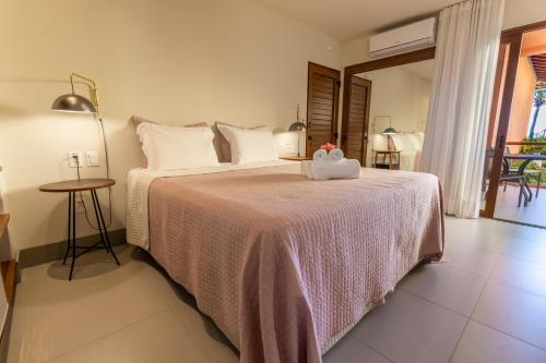 a bedroom with a bed with a stuffed animal on it at Club do Balanço Pousada e Restaurante in Morro de São Paulo