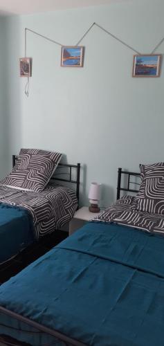 twee bedden naast elkaar in een slaapkamer bij L'Escale Cotinarde in La Cotinière