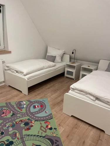 una camera con due letti e un tappeto di Ferienwohnung Wintermoor a Schneverdingen
